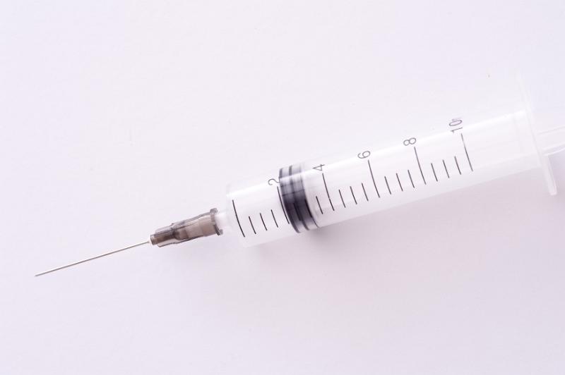 Free Stock Photo: Clean empty plastic disposable syringe and needle lying on a white background with copy space in a healthcare or drug addiction concept