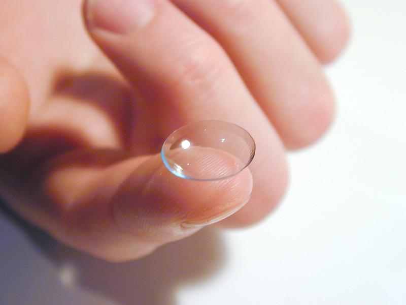 Free Stock Photo: Close Up of Person Holding Contact Lens on Tip of Finger on White Background