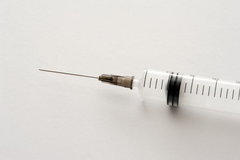 Free Stock Photo: Needle on a disposable plastic syringe over a grey background with copy space conceptual of injecting medication or drug addiction