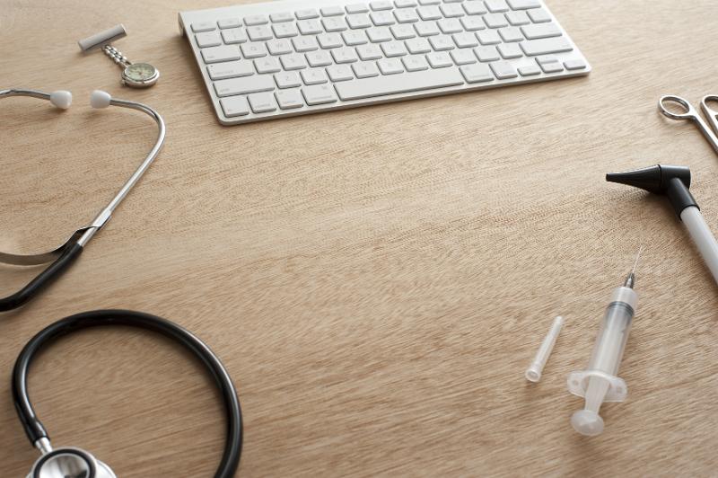 Free Stock Photo: High Angle View of Medical Supplies and Equipment Scattered Around Computer Keyboard on Wooden Desk with Copy Space