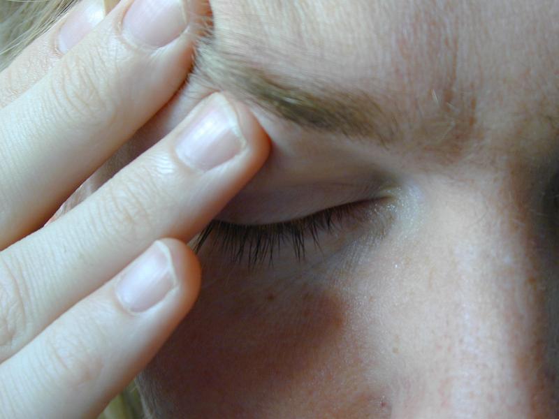 Free Stock Photo: Close Up of Person with Eyes Closed Rubbing Forehead Above Eye with Hand as if Stressed or Experiencing Headache