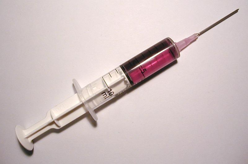Free Stock Photo: White plastic syringe filled with a dose of pink soluble medicine for an intravenous injection, close-up with copy space on gray