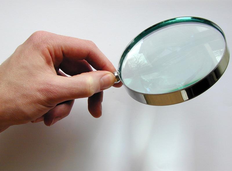 Free Stock Photo: Close Up of Hand Holding Magnifying Glass, Searching for Clues on White Background