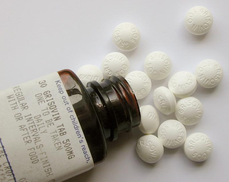 Free Stock Photo: High Angle View of Prescription Bottle with Label Spilling White Tablet Medications onto White Surface