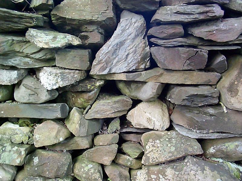 Free Stock Photo: Dry-stone wall formation with a wall constructed of assorted types of natural rock stacked on top of one another without mortar, full frame background texture
