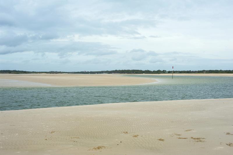 Free Stock Photo: River estuary crossing deserted golden beach sand as it winds its way to the sea under a cloudy sky