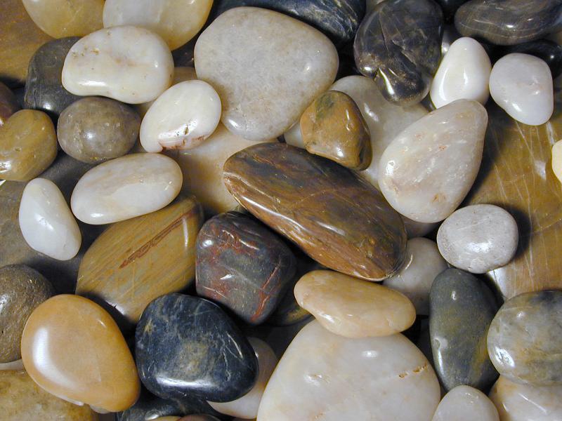 Free Stock Photo: Background texture of assorted colorful natural pebbles or stones worn smooth by the tumbling action of the water of the sea or a river
