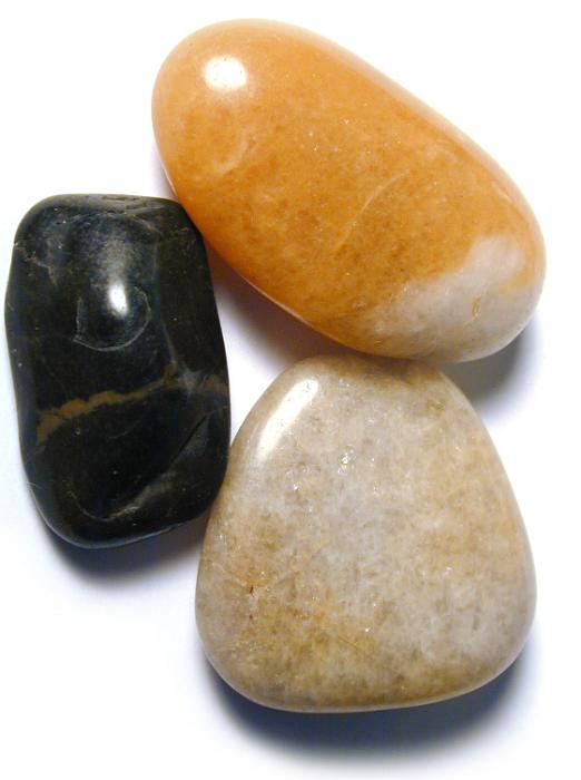 Free Stock Photo: Smooth natural stones or pebbles with surfaces polished by the tumbling action of the water at the seaside or in a river bed, viewed from above on white
