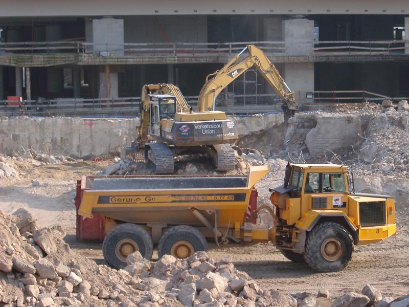 Free Stock Photo: An industrial excavator and dump truck excavating and clearing rubble at a construction site