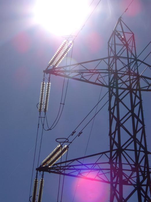 Free Stock Photo: View looking up into the sun of a high voltage electricity pylon with pink sun flare spots