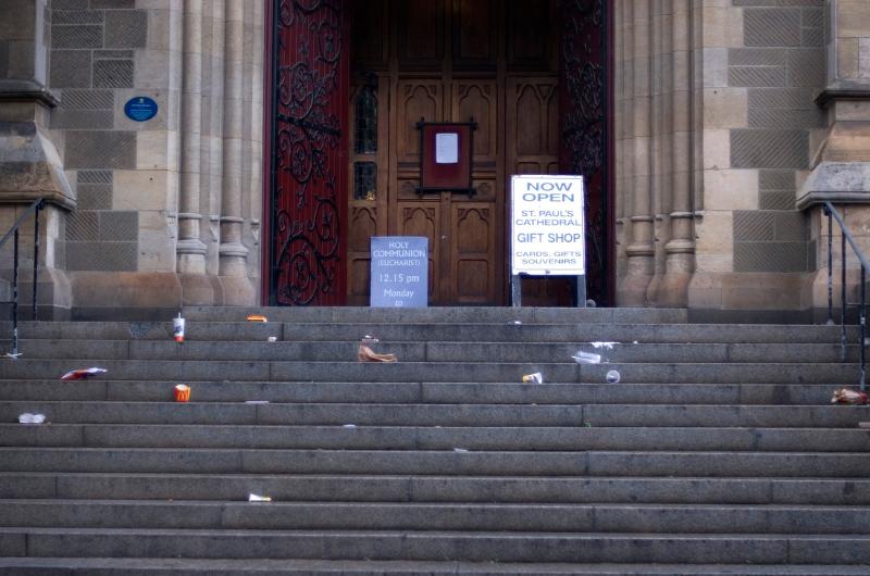 Free Stock Photo: Litter strewn stone steps in front of a public venue with scattered plastic and cardboard drinks cartons, paper and rubbish