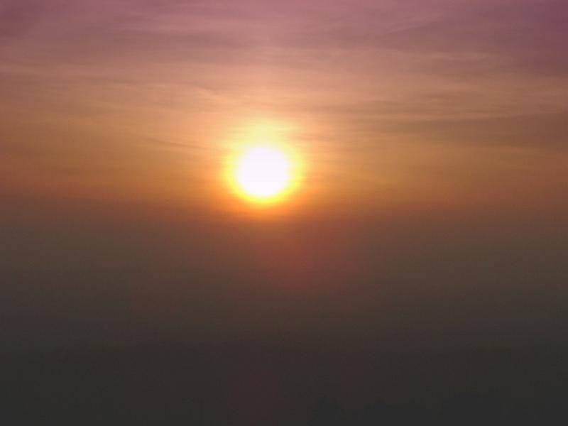 Free Stock Photo: Sun setting in a hazy smoggy polluted sky with muted blended colours of orange and purple