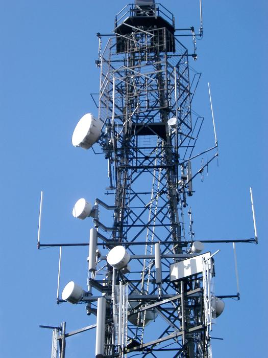 Free Stock Photo: Low angle view of a steel lattice communications tower with an array of dishes for transmission and reception