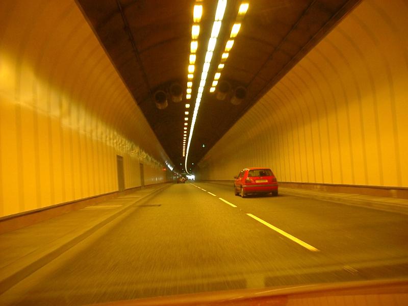 Free Stock Photo: Car driving through a covered illuminated traffic tunnel causing air pollution through exhaust emission in the confined space