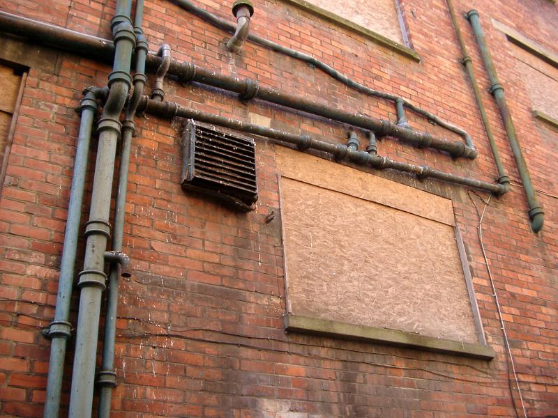 Free Stock Photo: Old pipework and plumbing on the exterior of a red brick building