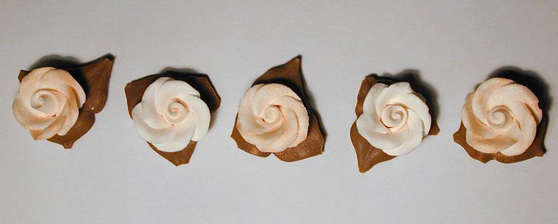 Free Stock Photo: Row of white icing flowers used in baking to decorate a cake viewed from overhead on a grey background in banner format