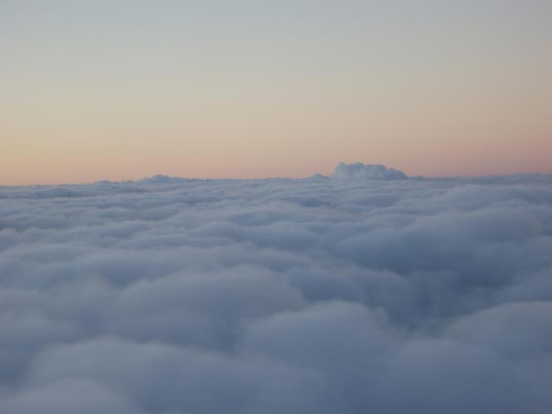 Free Stock Photo: Flying above the clouds with a colourful sunset or sunrise visible over a dense blanket of white clouds