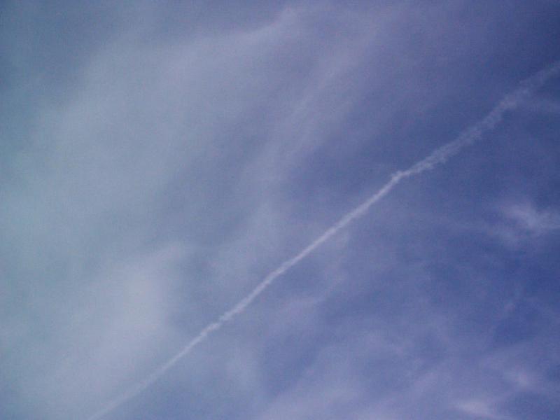 Free Stock Photo: Low Angle View of Jet Contrail Streaking Across Vast Blue Sky with Wispy Clouds
