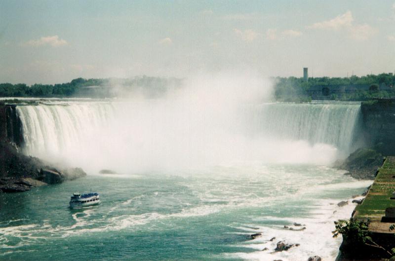 Free Stock Photo: View of Niagara Falls from downstream with a tourist boat approaching the foot of the waterfall and cloud of spray