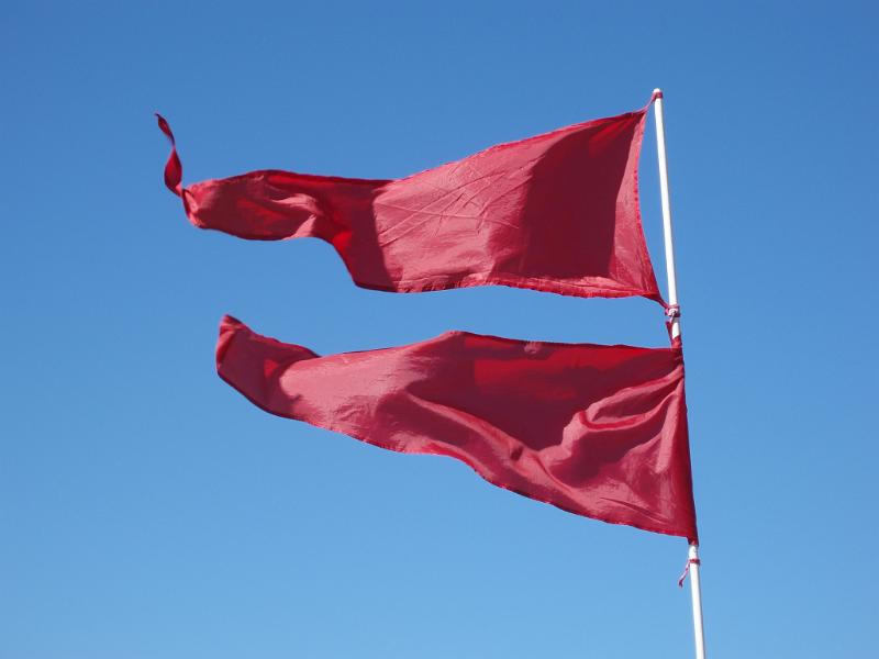 Free Stock Photo: bight red flags blowing in the wind on a sunny day