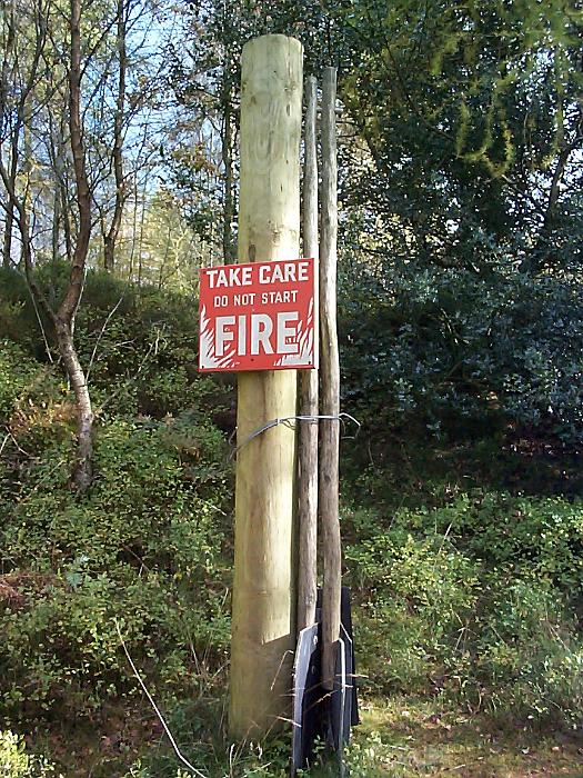 Free Stock Photo: Fire warning notice asking people to take care not to start a fire mounted on a pole in Cumbria woodland