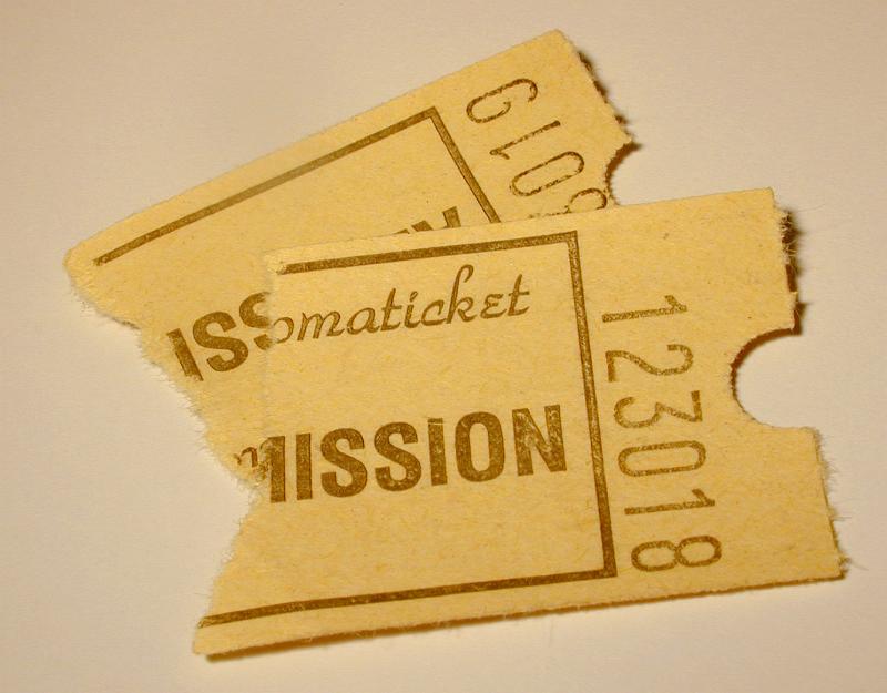 Free Stock Photo: Two admission ticket stubs with personal numbers, printed on vintage yellowish paper, viewed in close-up