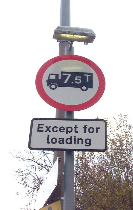 Free Stock Photo: 7.5 ton truck sign and loading zone limiting the size except when loading freight with street lamp above on a tall pole