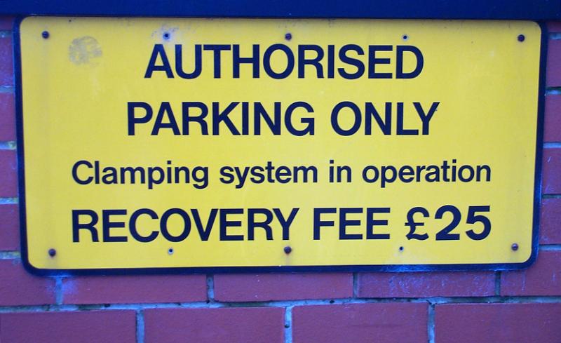 Free Stock Photo: Warning sign for Authorised Parking Only noting that there is clamping in place with a fine for vehicle recovery
