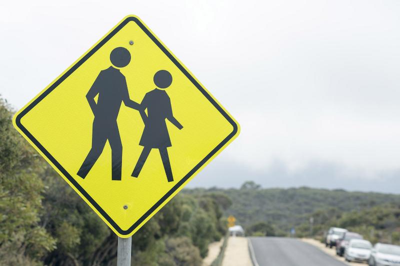 Free Stock Photo: Roadside yellow Pedestrian Crossing traffic warning sign on a rural road with parked cars on the shoulder