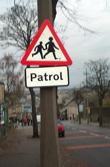 Free Stock Photo: Traffic warning sign for a school crossing and patrol on a pole at the side of an urban street