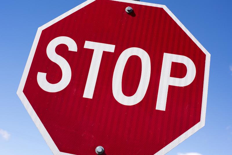 Free Stock Photo: Red octagonal Stop sign against blue sky viewed tilted at a close up low angle