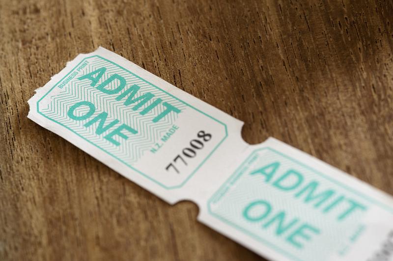 Free Stock Photo: Two generic unused joined admission tickets with unique numbers and text - Admit One - lying on a wooden table