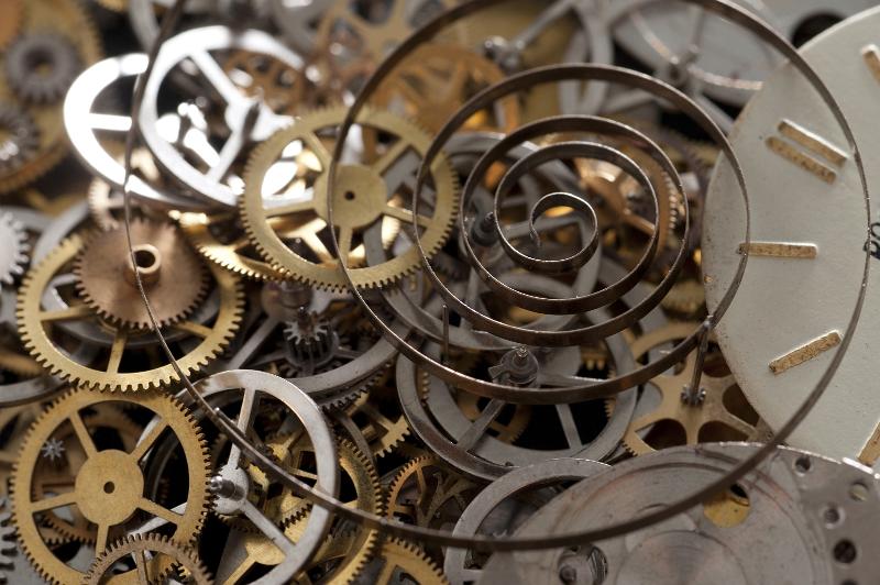 Free Stock Photo: Clock spring and a pile of brass gears in a watch repair or horology workshop