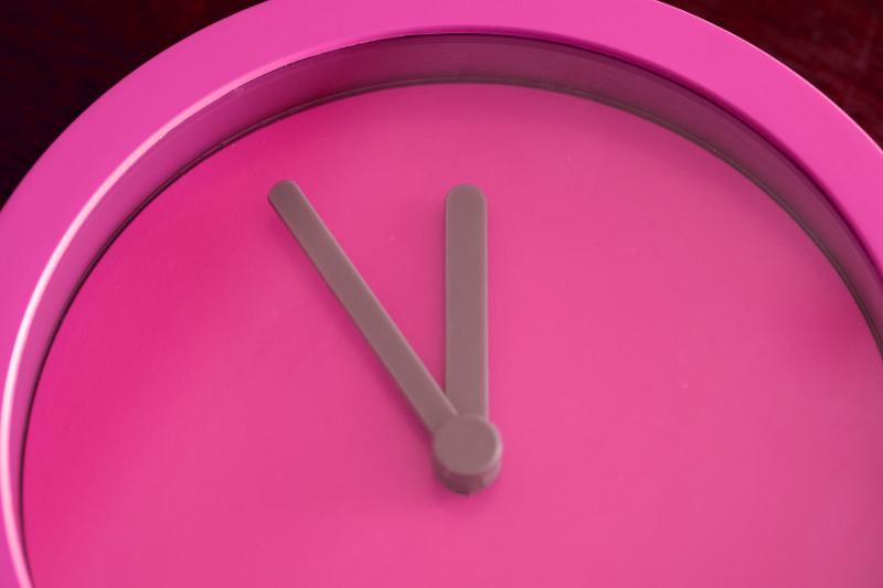 Free Stock Photo: Overhead close up view of bright pink clock with grey hands and no numbers