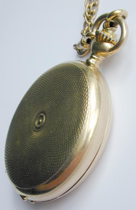 Free Stock Photo: Gold vintage full hunter pocket watch with a tooled engraved case and chain displayed closed at an angle