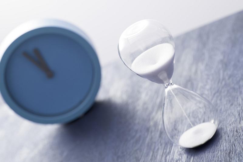 Free Stock Photo: Blue modern clock and egg timer or hourglass with sand running through the glass bulbs in a concept of measuring time