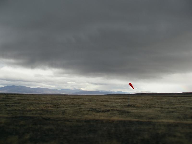 Free Stock Photo: stormy planes in newzealand, a single red windsock forms a moody atmospheric image