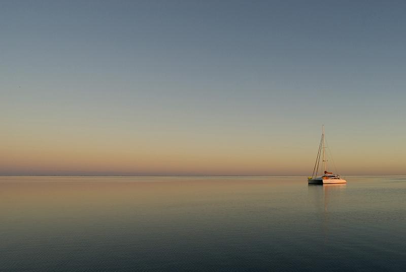 Download image of Tranquil Sunset Free Stock Photo: A boat anchored on an almost mirror flat lagoon at sunset