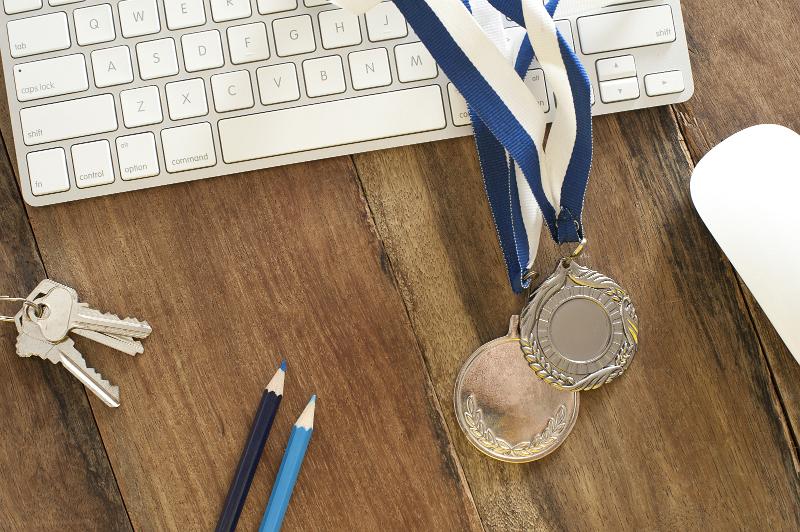 Free Stock Photo: office achievement award with a keyboard and two winners medals on a blue lanyard