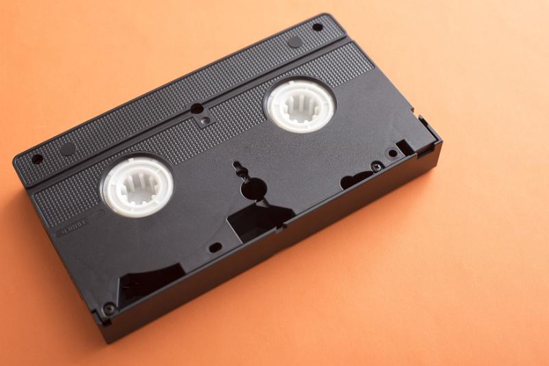 Free Stock Photo: Old plastic casing of a VHS video tape lying on an orange background with copy space viewed high angle