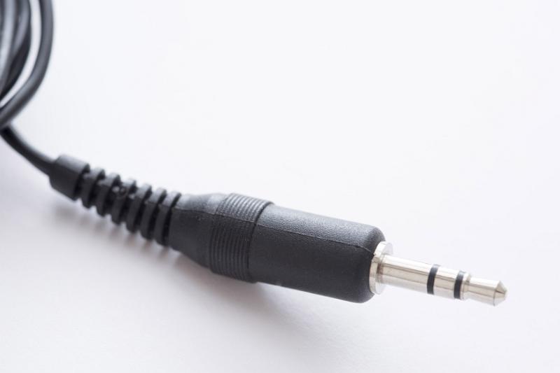 Free Stock Photo: Audio jack 3.5 mm stereo plug with black cord in plastic body close-up on white background with copy space