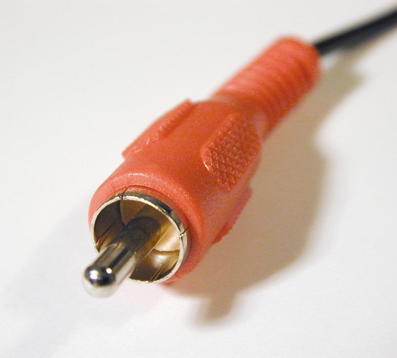 Free Stock Photo: Close up of small orange metal and rubber electrical contact connecter attached to plastic black wire