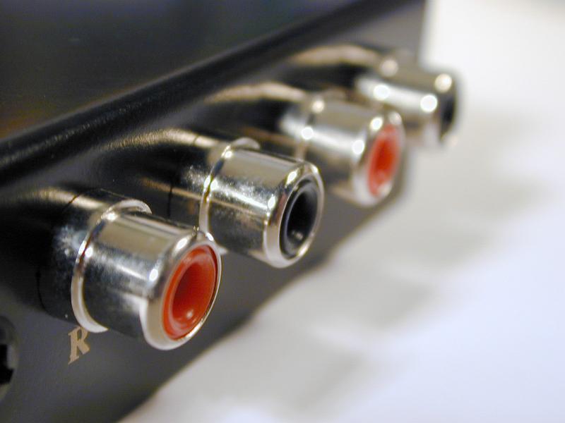 Free Stock Photo: Red and black analog RCA audio phono connections on black metal panel in close-up selective focus