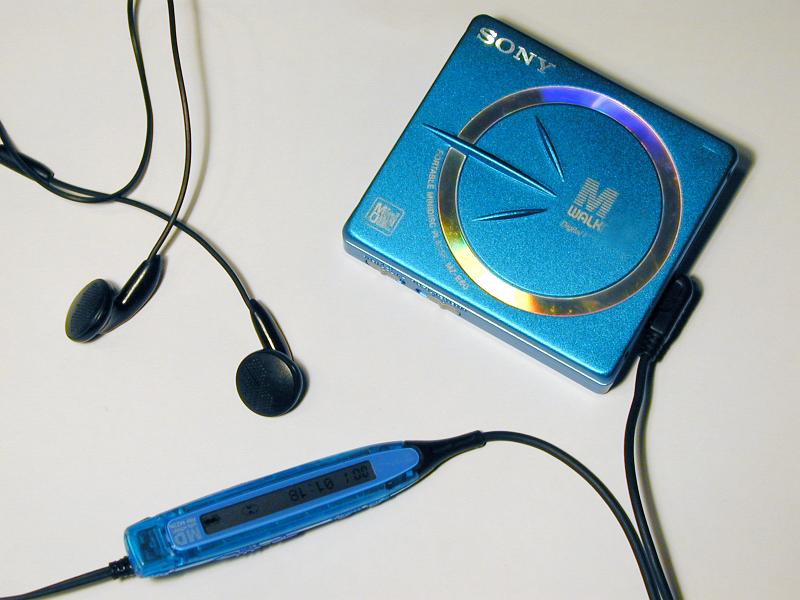 Free Stock Photo: Sony Mini Disk personal music player of blue color with black earbuds and on wire controls, from above close-up on white background