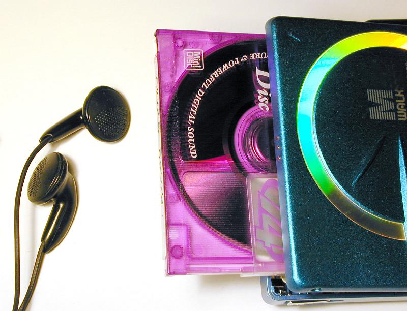 Free Stock Photo: Personal music concept with an audio disc in a colorful pink case and ear buds or earpieces over a white background