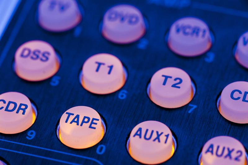 Free Stock Photo: Backlit glowing yellow remote control rubber keyboard, close-up on mode and media source choosing buttons