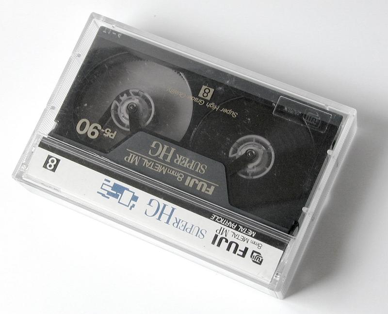 Free Stock Photo: Fuji 90 minute VHS video cassette with branding label in a clear plastic case on white viewed from above in an entertainment concept