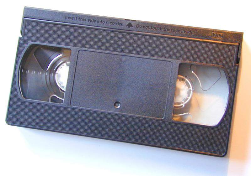 Free Stock Photo: Unlabelled generic VHS video cassette tape in a black plastic case on white viewed from above