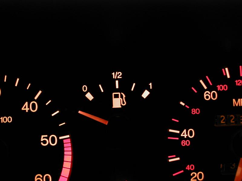 Free Stock Photo: Illuminated gauges on a car dash board display centered on the fuel readout with the needle in the off position