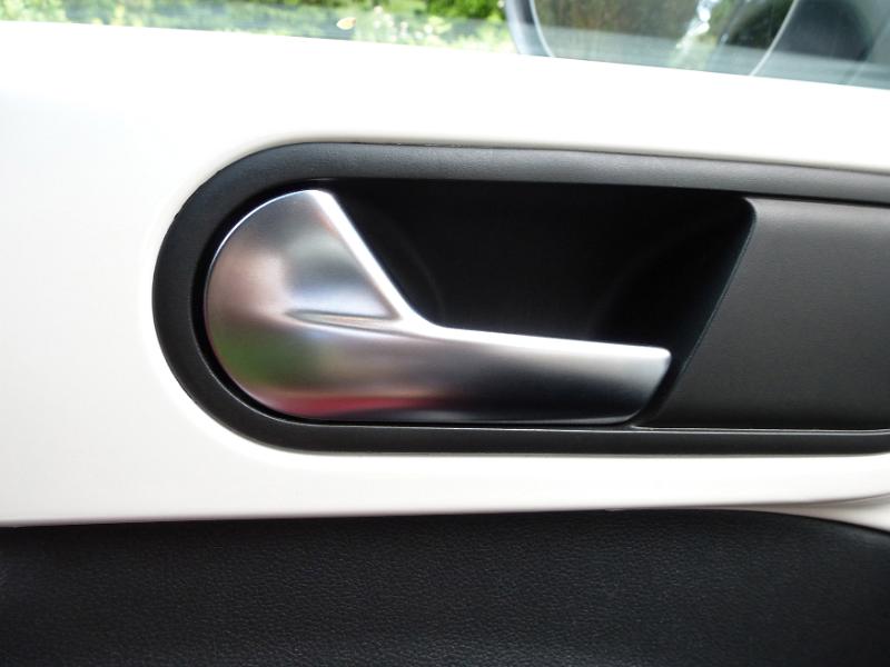 Free Stock Photo: Recessed silver metal car door handle on a white car in a close up view